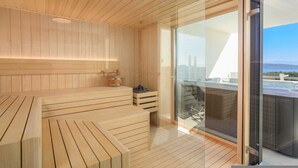 A modern sauna with wooden benches and a glass door leading to a balcony with a hot tub. - Villa LEA Magdalena III (Krk)