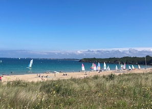 A beach with sailboats, people relaxing, and grassy areas. - House near the ocean with a large garden and direct access to the GR34 (Saint-Cast-le-Guildo)