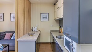 Una cocina compacta con microondas integrado, tostadora y bloque de cuchillos.