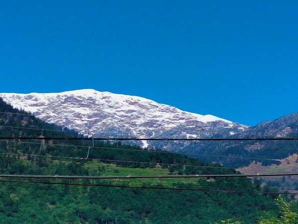 A mountain with snow-capped peaks and a clear blue sky.