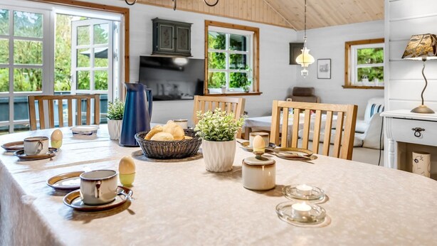 A cozy kitchen with wooden cabinets, a large island with breakfast items, and a view of greenery outside. - "Femme" by Interhome (Blåvand)