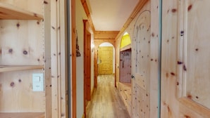 A wooden hallway with a door at the end, wooden walls, and a light switch on the left. - Well-kept holiday apartament house in a prime location in St. (St. Moritz)
