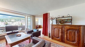 Relax in this stylish living room with a large flat-screen TV, comfortable seating, and a beautiful view.