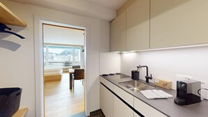 A modern kitchen with a built-in stove, a sink, and a window overlooking a cityscape. - Well-kept holiday apartament house in a prime location in St. (St. Moritz)