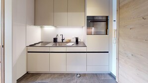 A modern kitchen with a black countertop, white cabinets, and a built-in oven. - Well-kept holiday apartament house in a prime location in St. (St. Moritz)