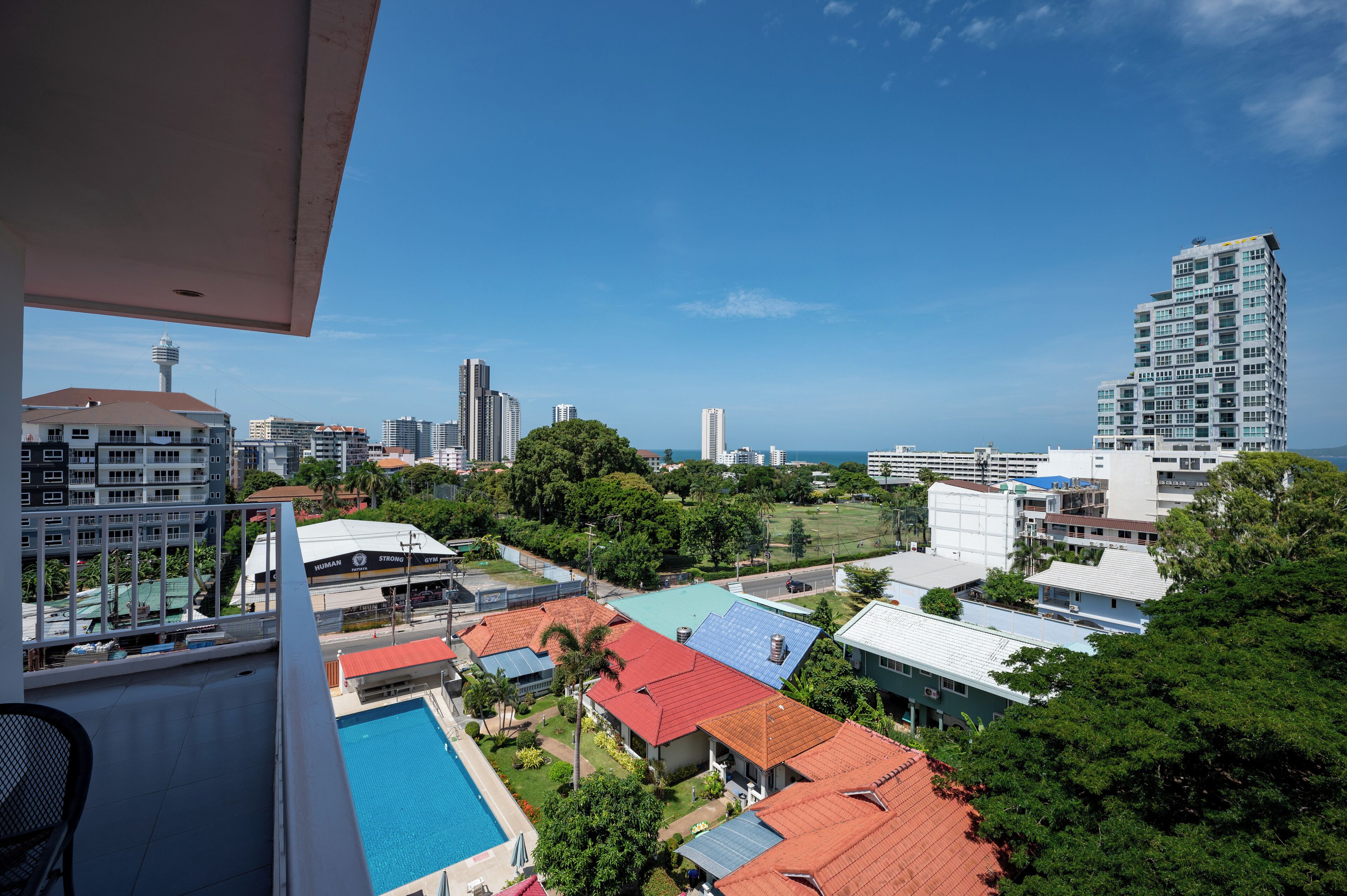 A high-rise building with a view of a swimming pool and surrounding residential buildings.