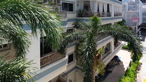 A multi-story building with balconies, a 'For Sale' sign, and surrounding greenery. - New Nordic VIP 6 Kristine (Pattaya)