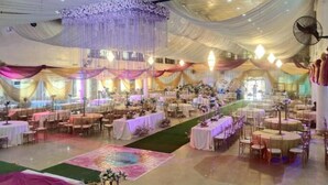 A banquet hall with multiple round tables and chairs, draped with white and pink fabric, and a central floral arrangement. - Remo Majestic Hotel (Sagamu)