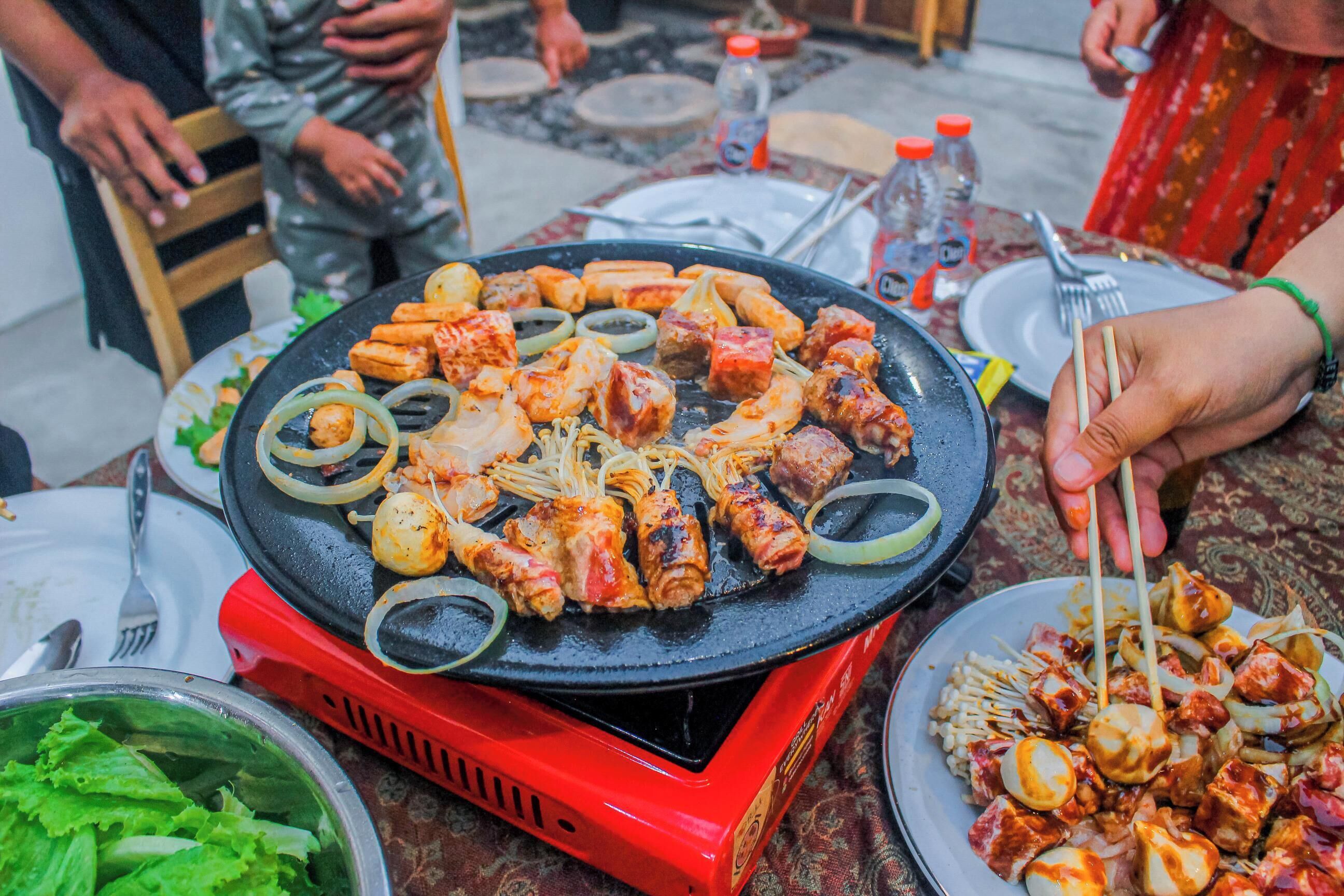 Een hete grill met diverse vleessoorten en groenten.