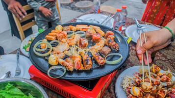Een hete grill met diverse vleessoorten en groenten.