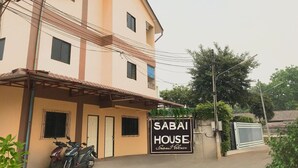 A two-story building with a sign reading "SABAI HOUSE". - Cozy 1-bedroom with WiFi and AC in delightful Chiang Mai, Self-check-in, Parking (Chang Wat Chiang Mai)