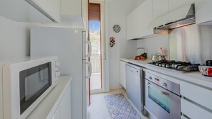 A modern kitchen with a microwave, stove, oven, and dishwasher. - Rhapsody By The Sea in Sanremo (Sanremo)