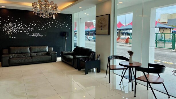 A modern lobby with a black leather sofa, a chandelier, and a coffee table. - Hotel Dlima Inn Plaza Mahkota Melaka (Malacca City)