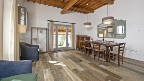 A spacious dining area with a wooden table and chairs, a large mirror, and a view of the outdoors through a glass door. - Fontesecca in Citt Della Pieve (Citta della Pieve)