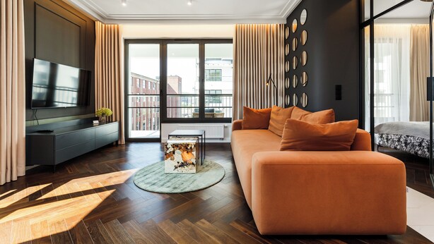 Ein modernes Wohnzimmer mit einem großen Flachbildfernseher, einer Couch und einem Couchtisch.