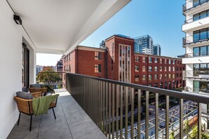 Enjoy breathtaking views of the city from this stylish balcony with a flat roof, perfect for relaxing with a cup of coffee and taking in the sights.