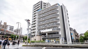 A modern multi-story building with a distinctive wavy facade, likely a hotel or office building. - BON Osaka West (Osaka)