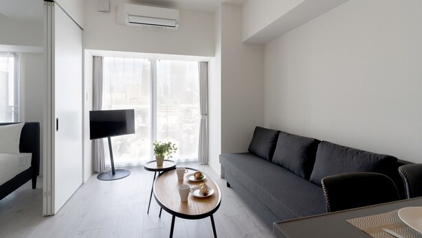 A modern living room with a sofa, a coffee table, and a TV. - BON Osaka West (Osaka)