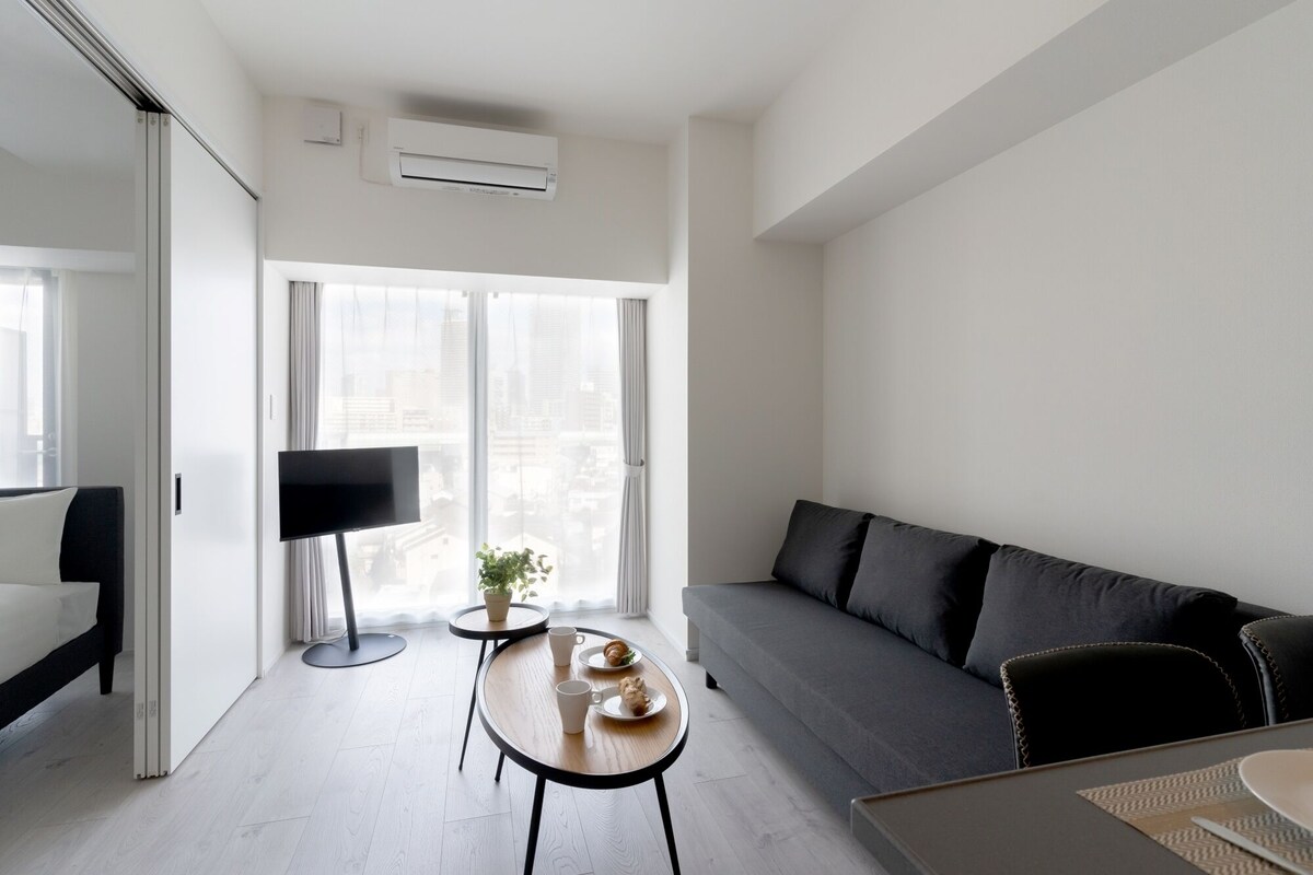 Un salon moderne avec un canapé, une table basse et un téléviseur.