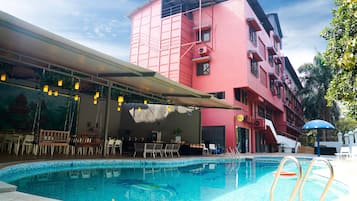 Relax by the pool with lounge chairs and umbrellas, or dine at the adjacent covered seating area.