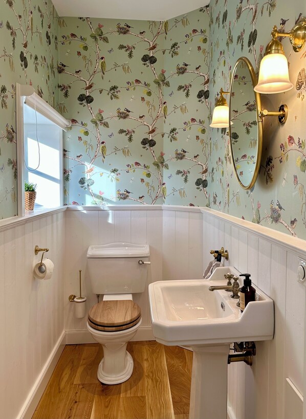 A bathroom with a toilet, sink, and a mirror.