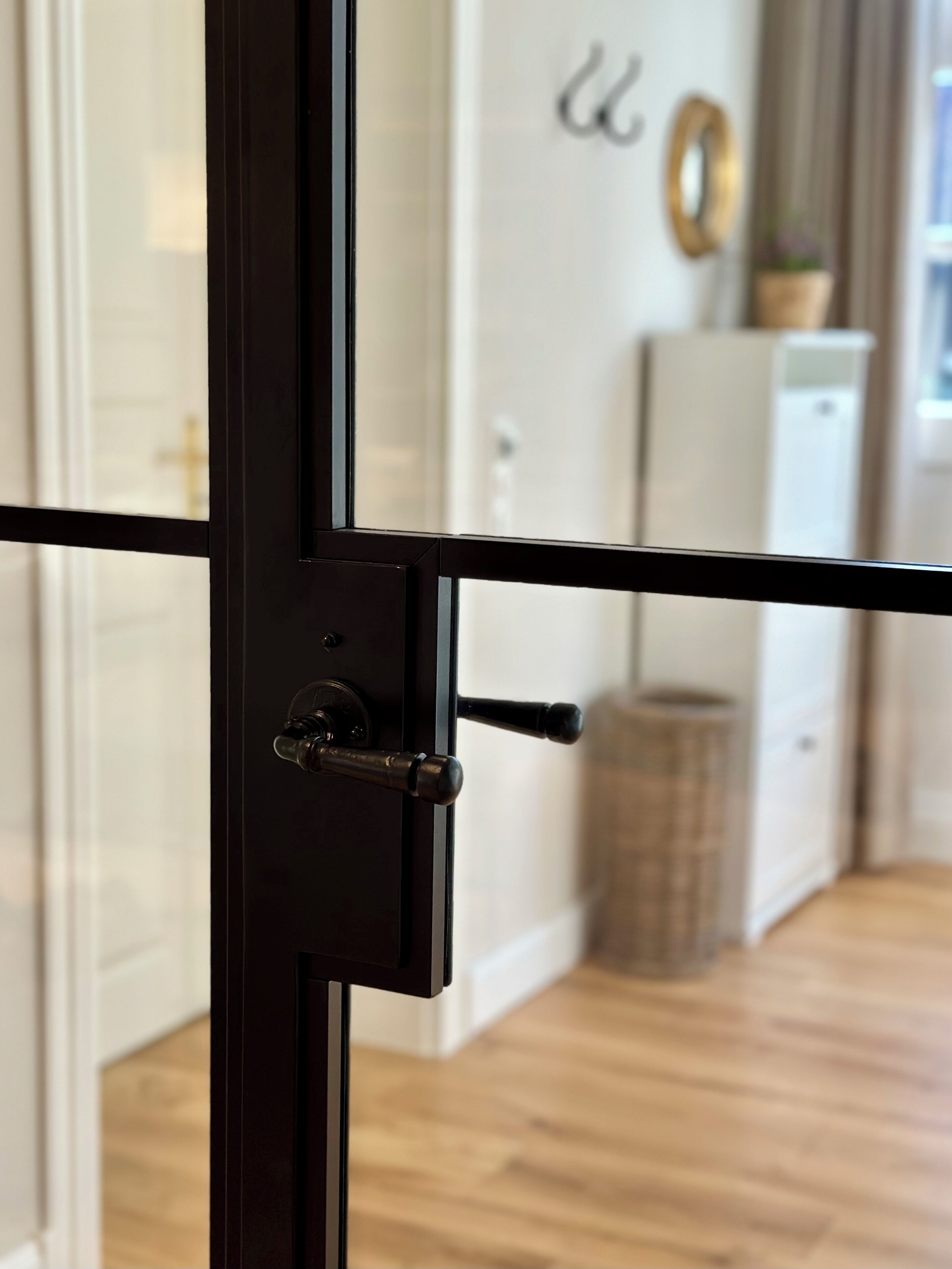 A close-up of a black door with a handle and a lock mechanism.