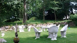 A garden with various white stone sculptures and a metal sculpture on a tripod. - 2-person Room in a Hotel in Tranekaer (Tranekaer)