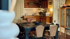 A dining area with a brick wall, wooden cabinets, and a table with chairs. - Large, 2 BR stable conversion (circa 1874) tucked in the heart of old town. 🍃 (Echuca)