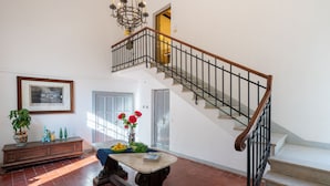 A spacious living area with a staircase, a dining table, and a bench. - Sunset Populonia by Geco Vacation Rentals (Piombino)