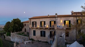 A two-story building with a balcony, a view of a lake, and a moon in the sky. - Sunset Populonia by Geco Vacation Rentals (Piombino)