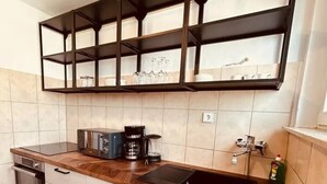Una cocina moderna con horno empotrado, cafetera y lavamanos.