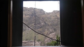 A window with a view of a mountainous landscape. - Hotel Grand Kailash (Joshimath)
