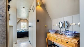 Ein modernes Badezimmer mit einem Holzwaschtisch, zwei großen Dekoschüsseln und einem Spiegel.