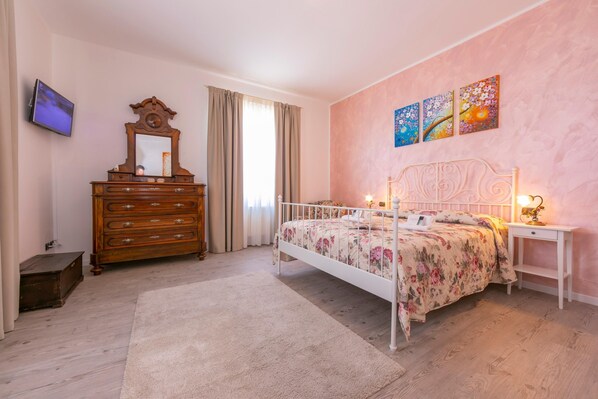 Un dormitorio con cama, cómoda y obra de arte en la pared.