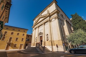 A historic building with a grand entrance, a staircase leading to the main door, and a clear blue sky. - Casa Mondragon In Lazise (Lazise)