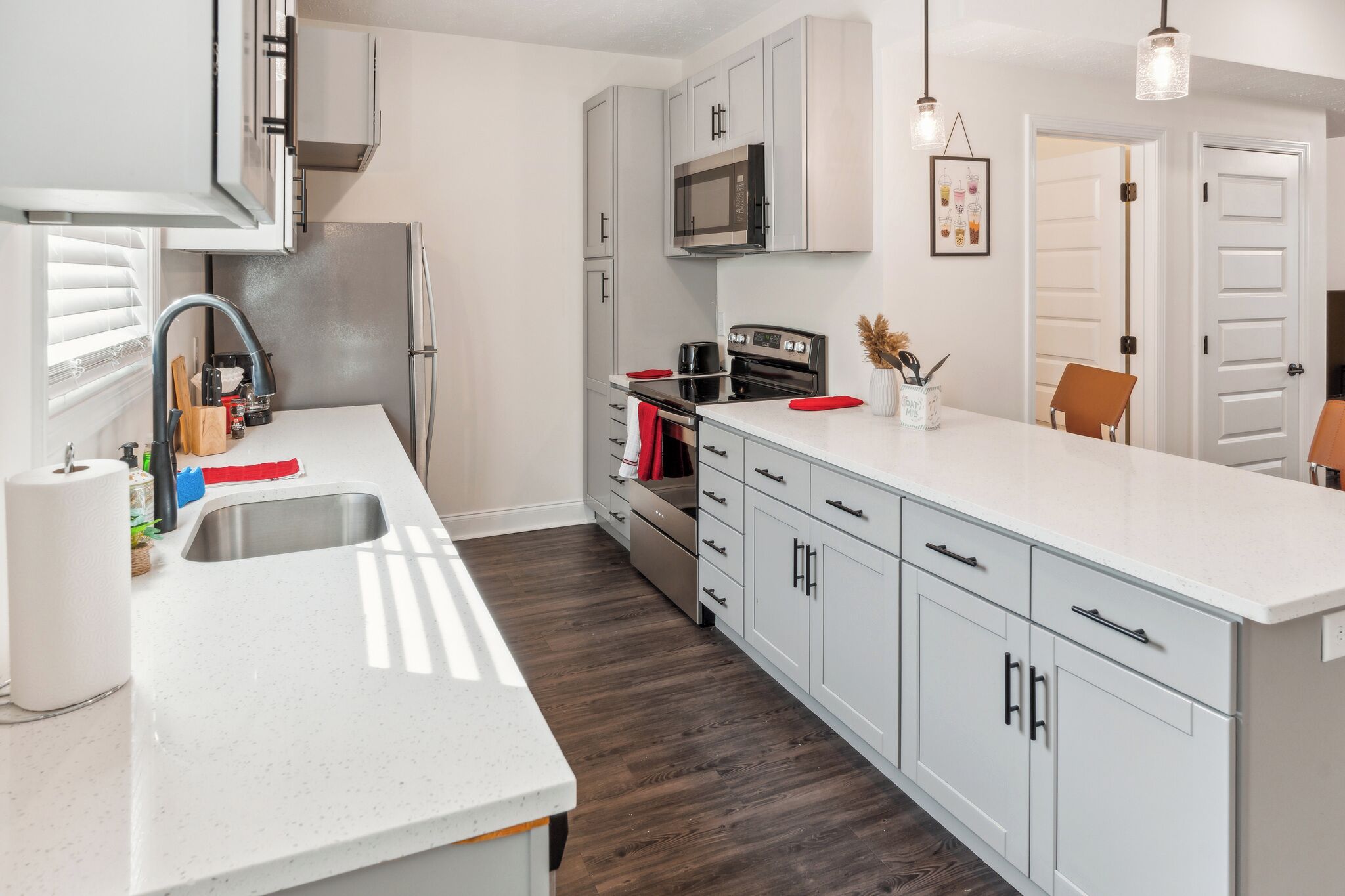 Una cocina moderna con armarios blancos, electrodomésticos de acero inoxidable y una isla grande.