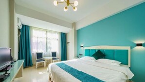 Ein Hotelzimmer mit einem großen Bett, einem Fernseher, einem Schreibtisch und einem Sessel.