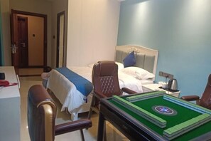 A hotel room with a bed, a desk, a chair, and a pool table. - Tinglan Light Stay Hotel (Haikou)