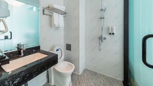 Ein modernes Badezimmer mit Marmorwaschtisch, Toilette und Dusche.