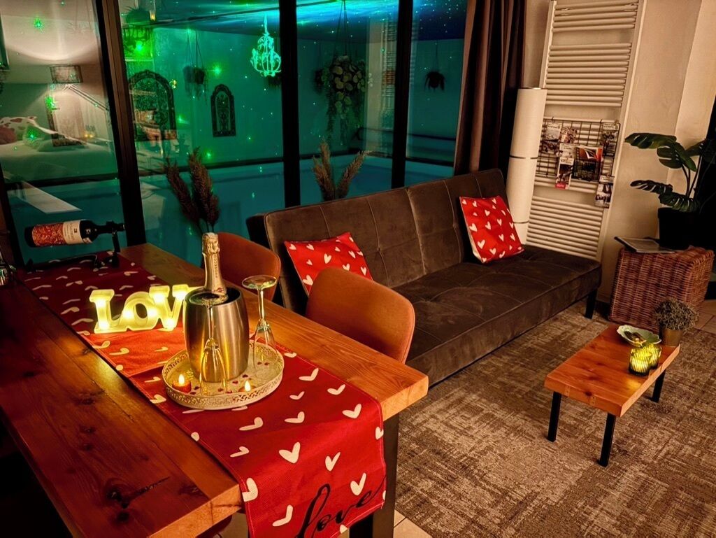 Een gezellige woonkamer met een bank, een houten salontafel en een rode tafelkleed met hartjes.