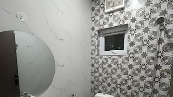 Chuveiro, toalhas de banho, sabonete, papel higiênico