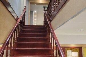 Una escalera de madera con barandilla que conduce a un piso superior.