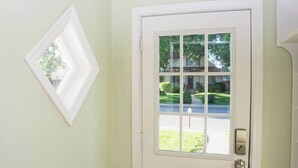 Eine weiße Tür mit einem Glasfenster und einem kleinen Fenster darüber.