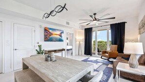 A modern hotel room with a dining area, a sofa, a lamp, and a ceiling fan. - RIVER FLY IN: The Cocoa, Island Horizon View (Merritt Island)
