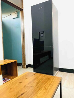 Compact room with a dining or work space, featuring a table and mirror.