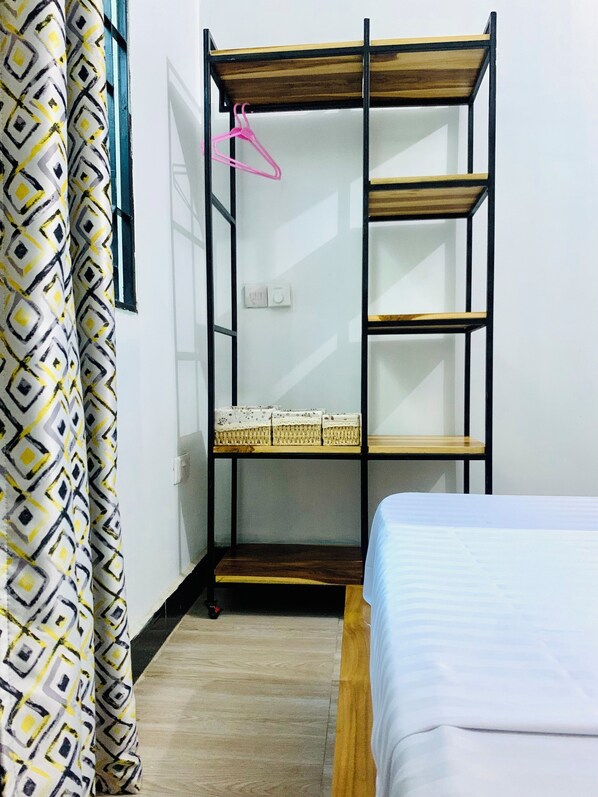Cozy retreat with a bunk bed and single bed, featuring a wooden table and wall-mounted shelf.