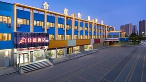 A multi-story hotel with a blue facade and a prominent sign on the ground floor. - Heyi Express Hotel (Zhuhai Baijiao Science Park Doumen Bus Terminal) (Zhuhai)