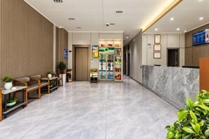 A hotel lobby with a reception desk, seating area, and a refreshment kiosk. - Heyi Express Hotel (Zhuhai Baijiao Science Park Doumen Bus Terminal) (Zhuhai)