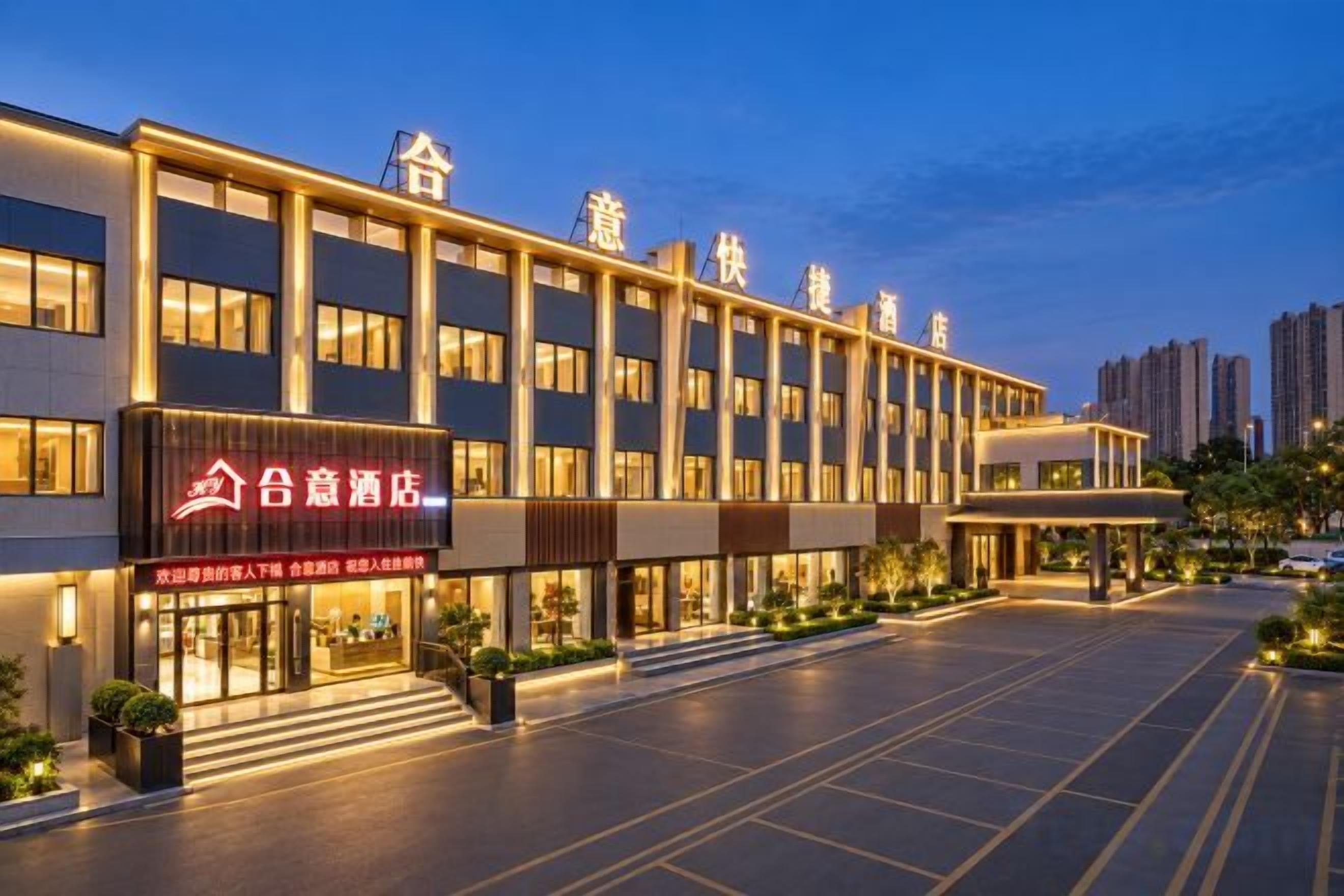 A hotel with a modern facade, a prominent entrance, and a parking area.