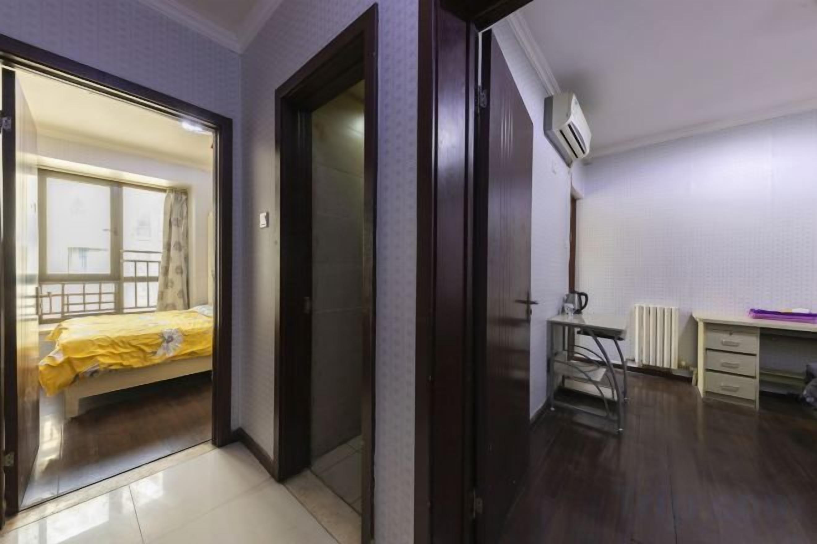 A room with a bed, a desk, and a radiator.